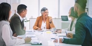 Five executives sit at a conference table during a consulting session with Nextuple