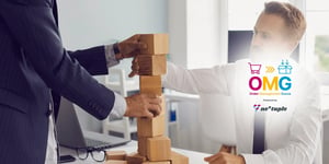 Two people in an office stack wooden blocks on top of each other.