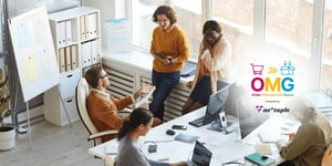 A group of five product managers huddle together in an office.