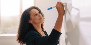 Woman writing rules on a whiteboard.